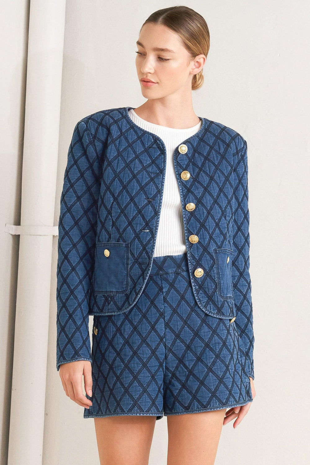 A quilted woven jacket featuring round neckline, long sleeve and front button down.