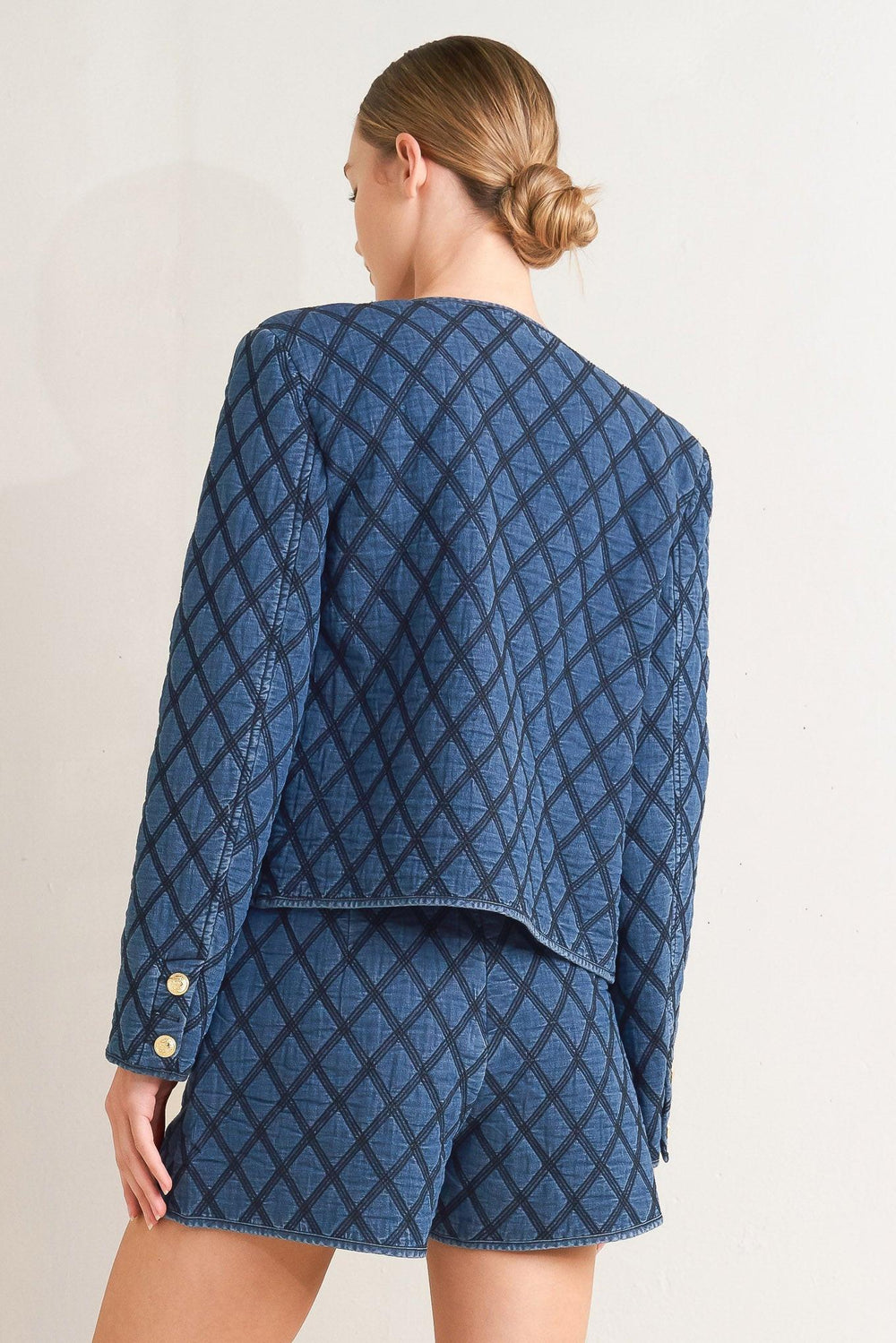 A quilted woven jacket featuring round neckline, long sleeve and front button down.