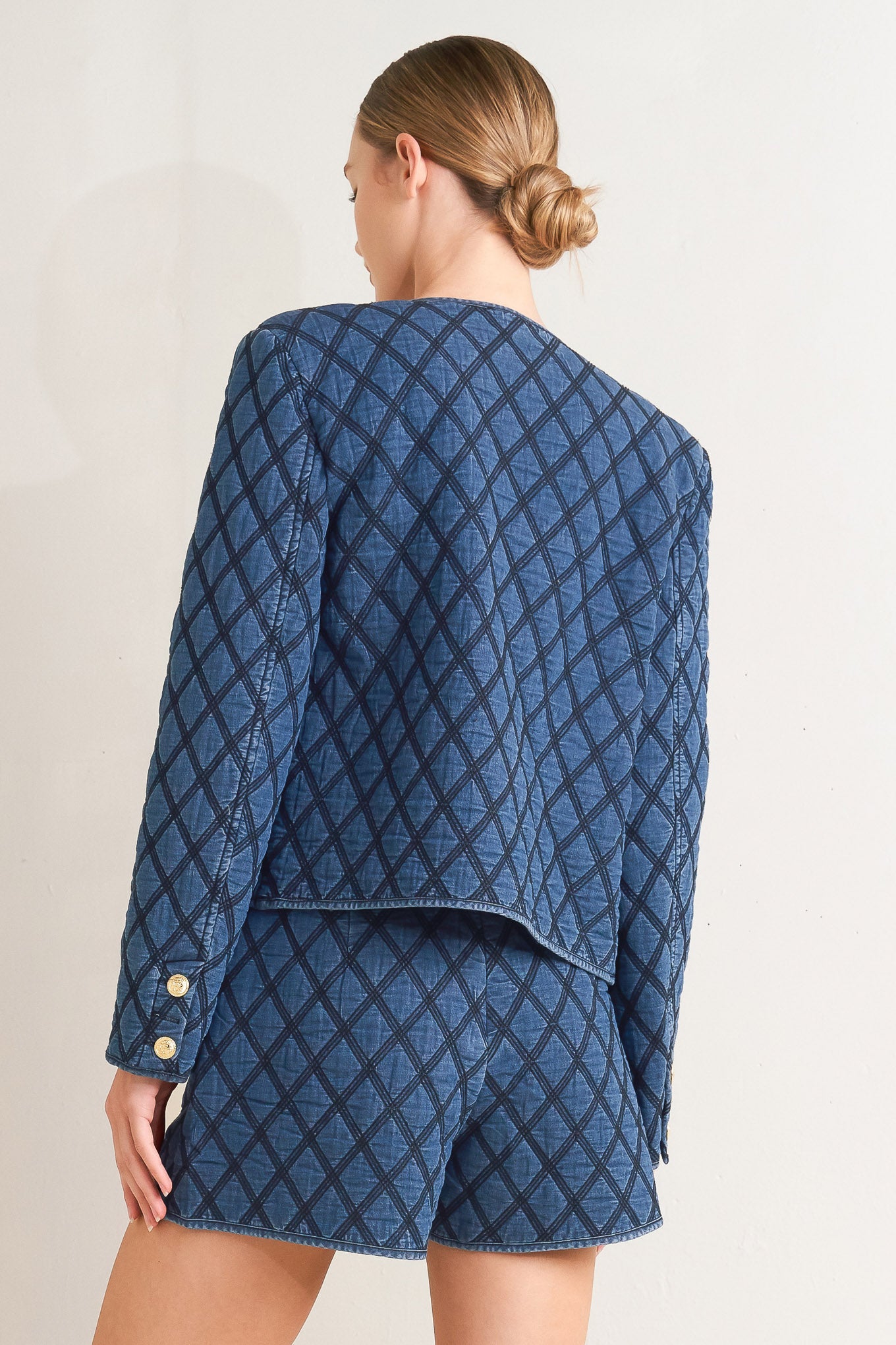 A quilted woven jacket featuring round neckline, long sleeve and front button down.