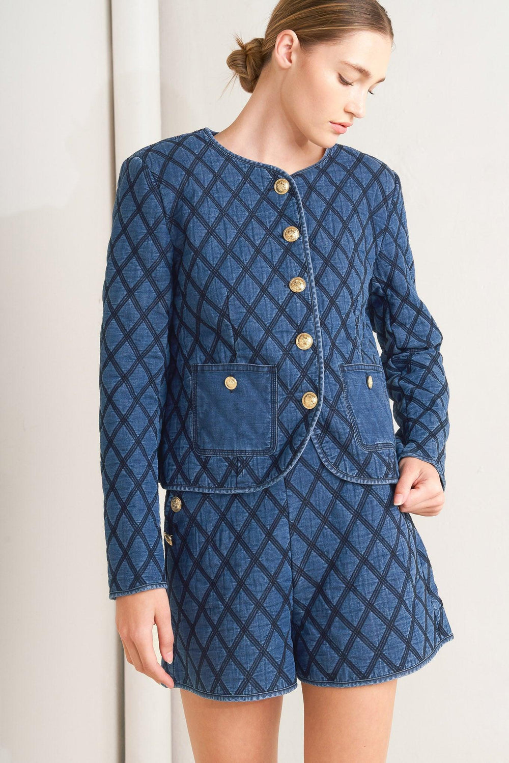 A quilted woven jacket featuring round neckline, long sleeve and front button down.