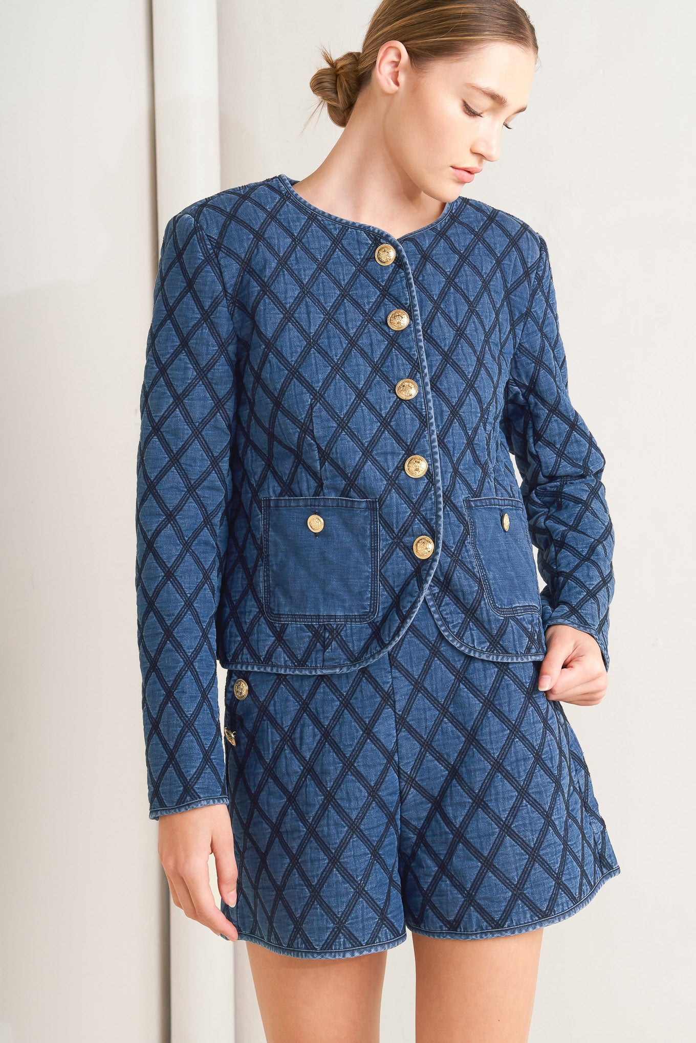 A quilted woven jacket featuring round neckline, long sleeve and front button down.
