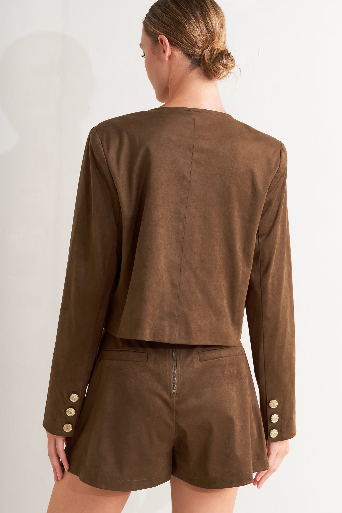 A faux suede cropped jacket featuring round neckline, long sleeve, front pockets and button down.