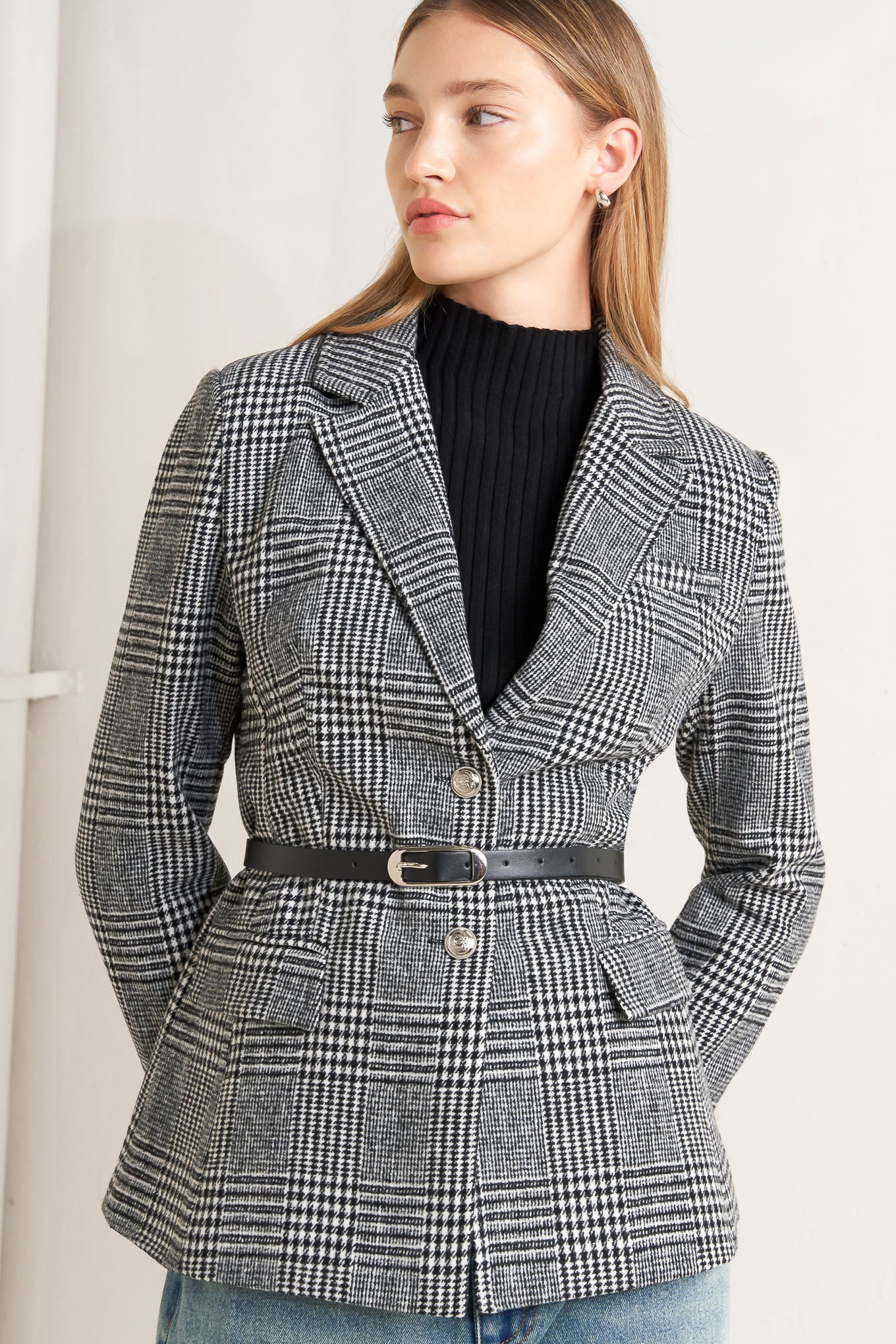 A woolen woven plaid jacket with front closure.