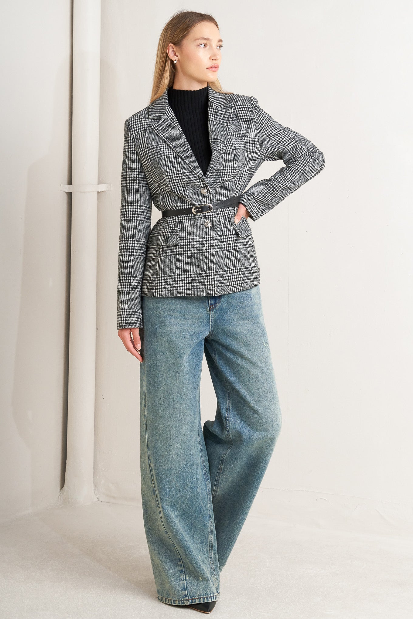 A woolen woven plaid jacket with front closure.