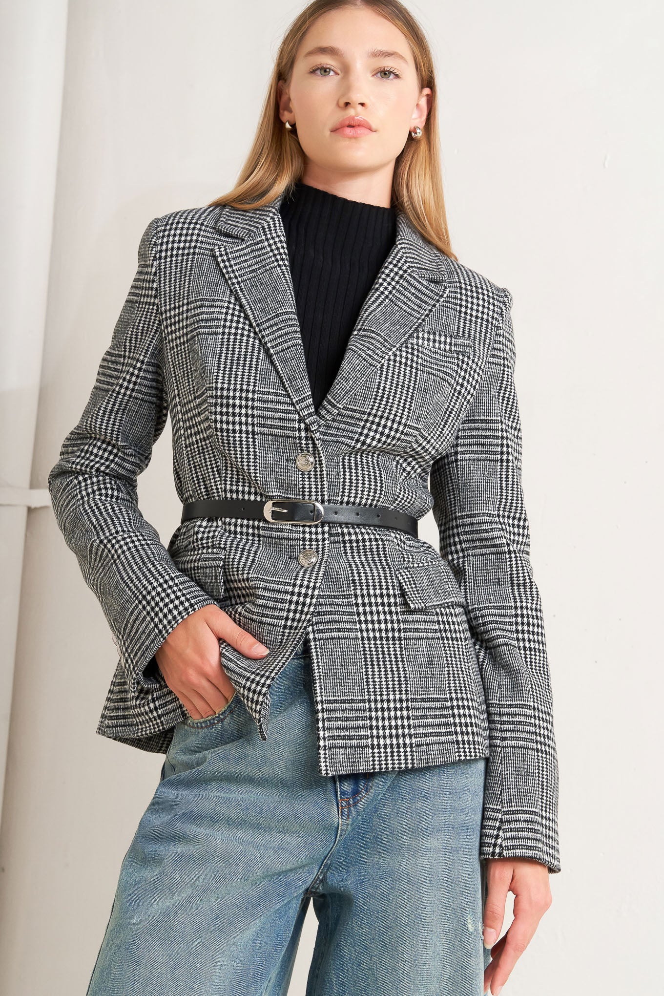 A woolen woven plaid jacket with front closure.
