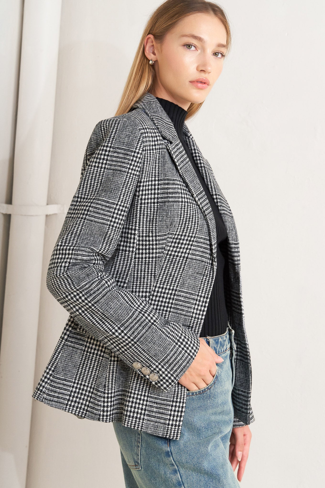 A woolen woven plaid jacket with front closure.