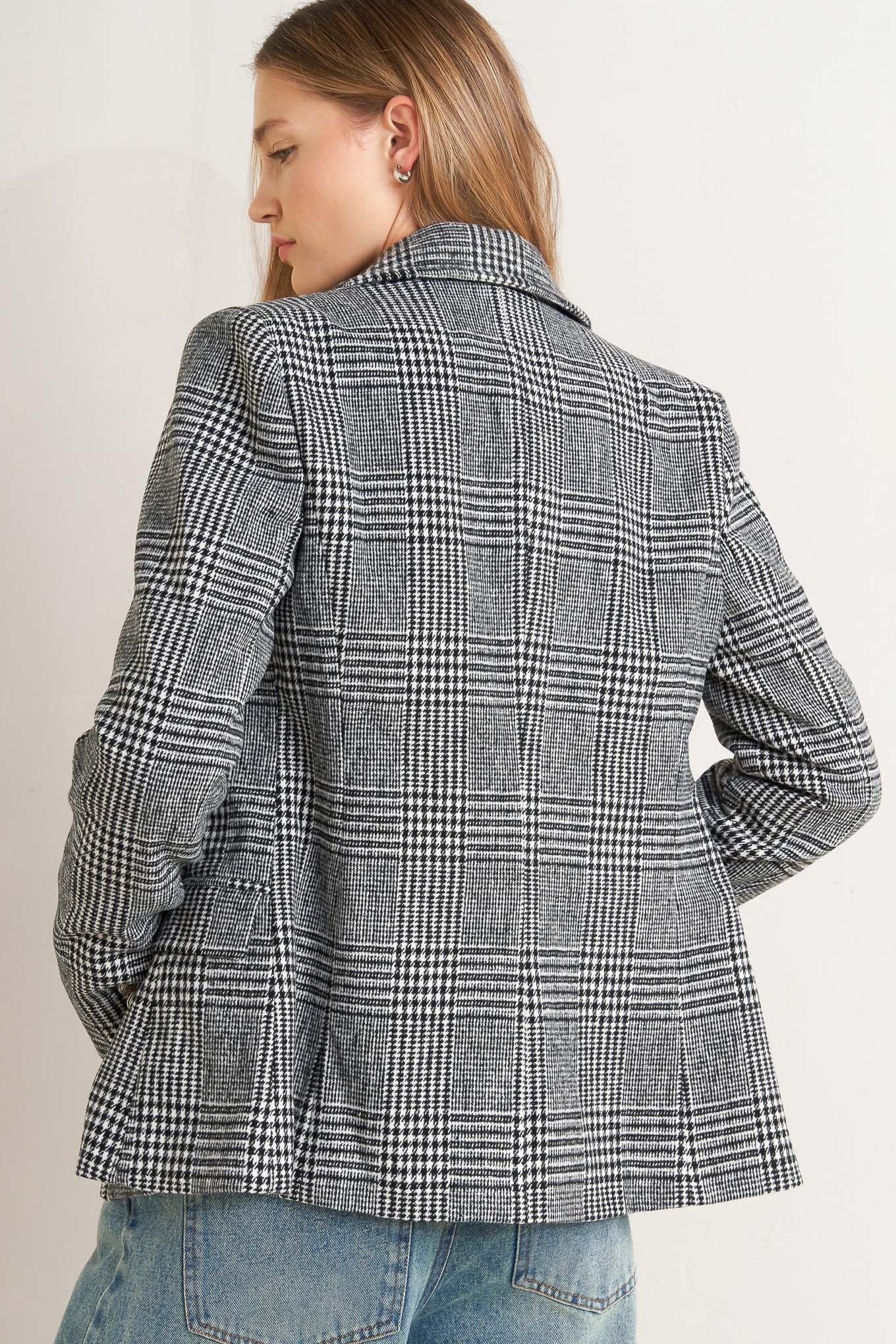 A woolen woven plaid jacket with front closure.