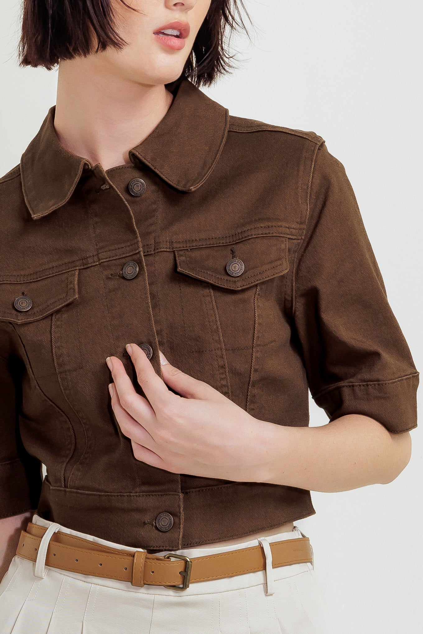 Woman wearing a brown short sleeve twill jacket with front button closure | FREEMARKET