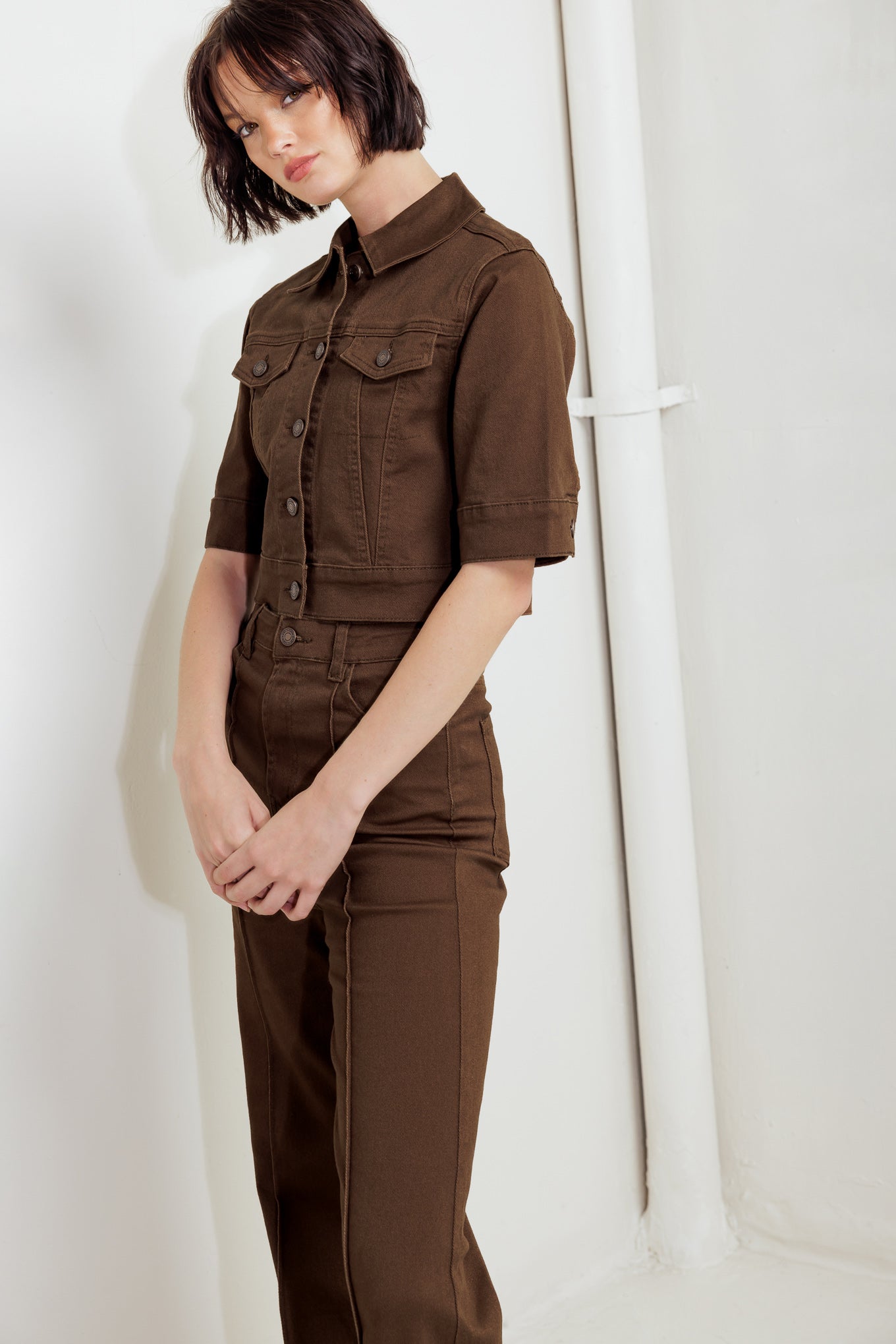 Woman wearing a brown short sleeve twill jacket with front button closure | FREEMARKET