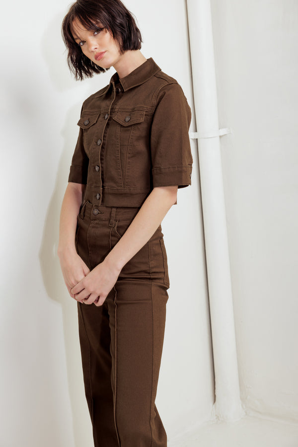 Woman wearing a brown short sleeve twill jacket with front button closure | FREEMARKET
