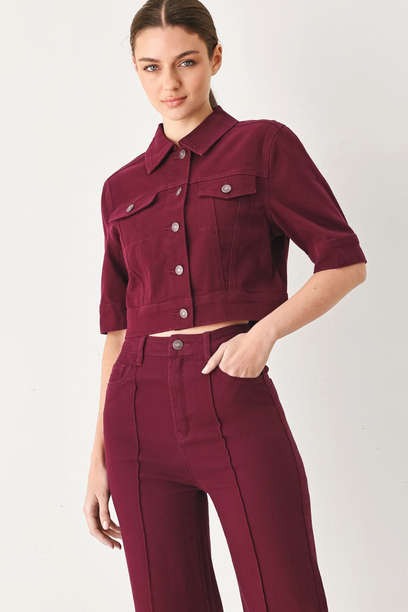 Woman wearing a burgundy short sleeve twill jacket with front button closure | FREEMARKET