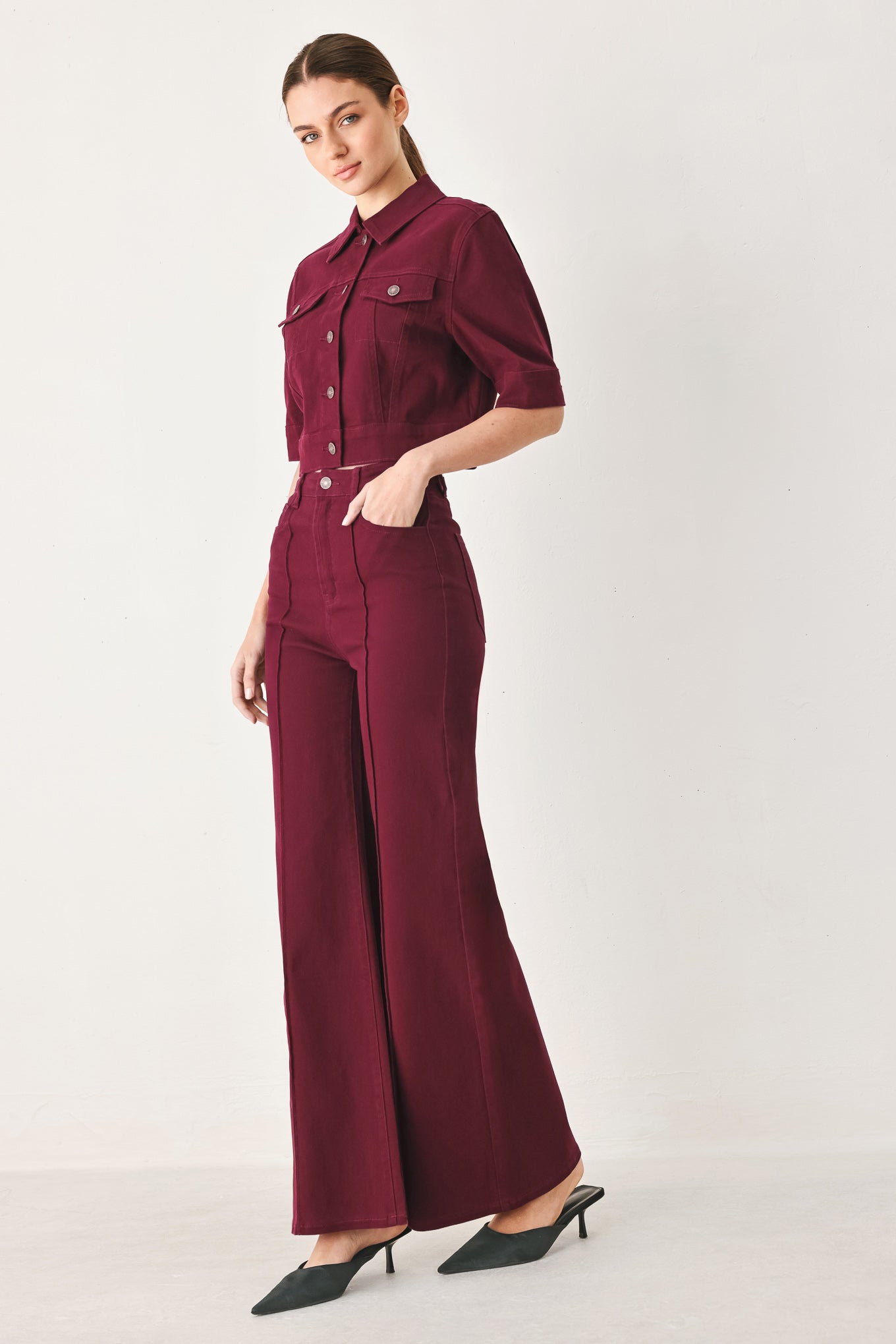 Woman wearing a burgundy short sleeve twill jacket with front button closure | FREEMARKET