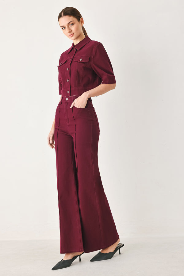 Woman wearing a burgundy short sleeve twill jacket with front button closure | FREEMARKET