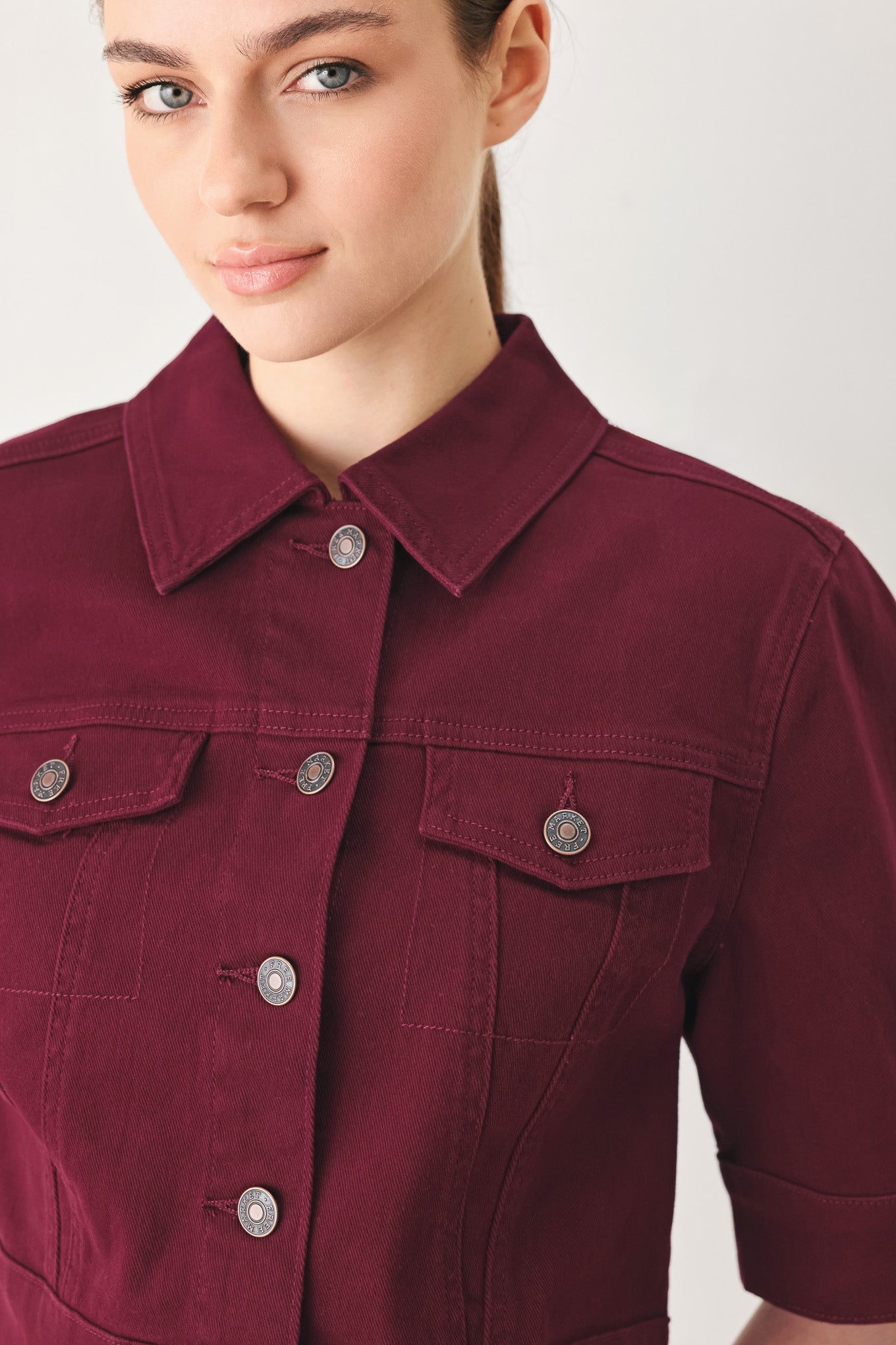 Woman wearing a burgundy short sleeve twill jacket with front button closure | FREEMARKET