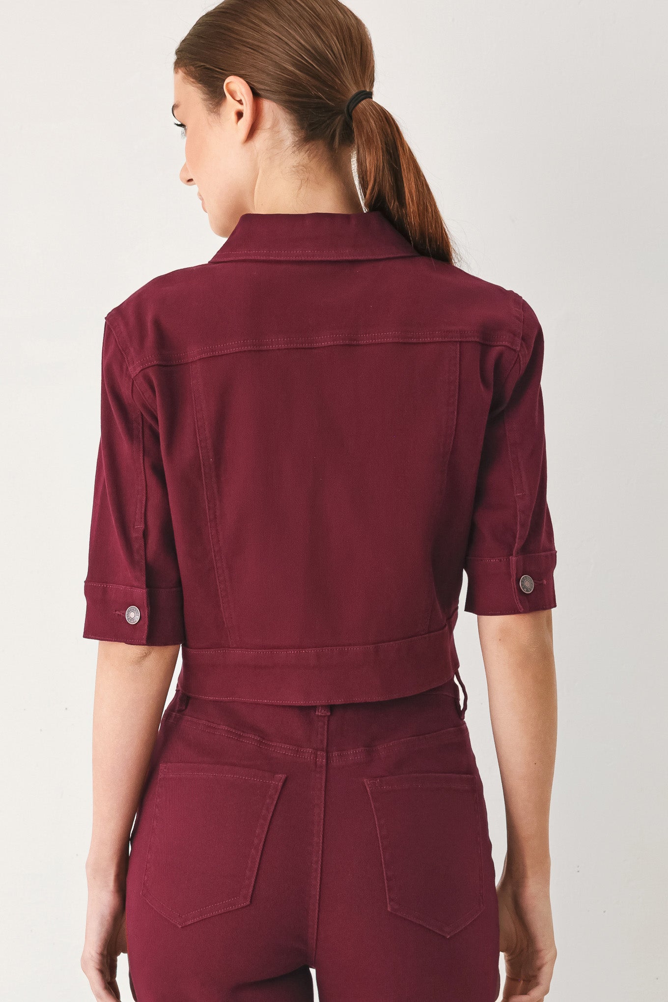 Woman wearing a burgundy short sleeve twill jacket with front button closure | FREEMARKET
