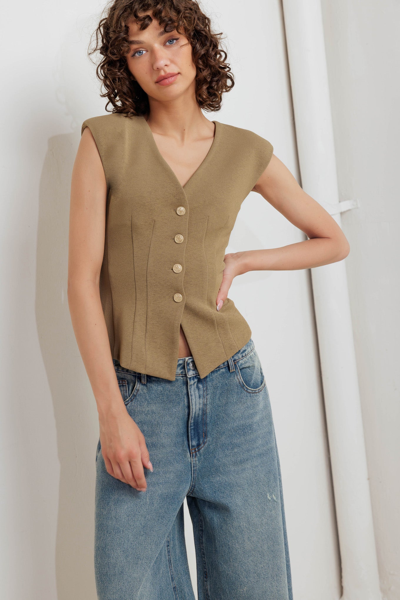 A solid woven vest with V neckline and front button closure