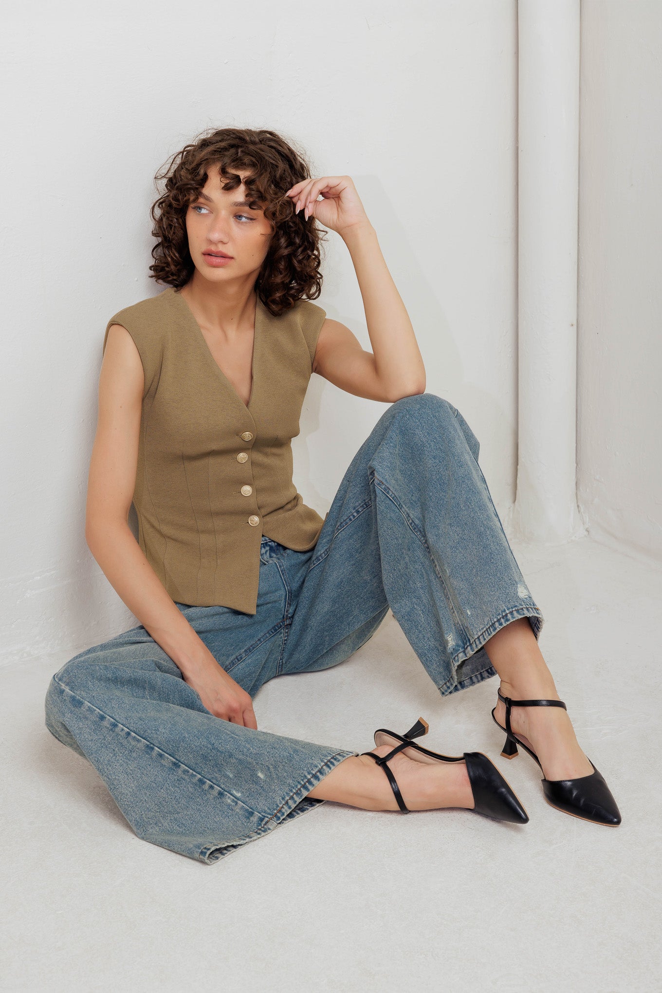 A solid woven vest with V neckline and front button closure