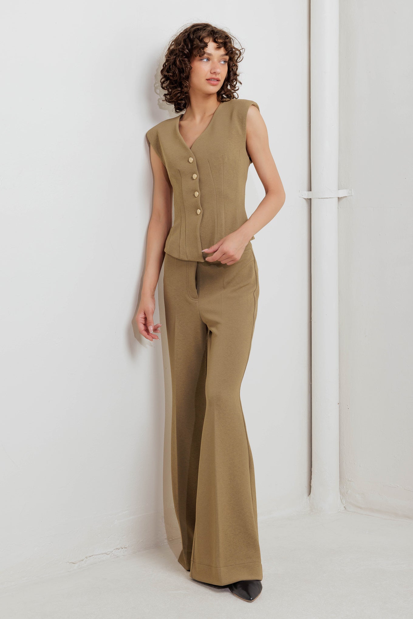 A solid woven vest with V neckline and front button closure