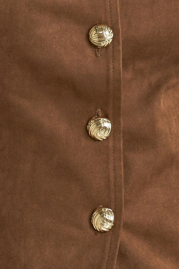 A faux suede vest featuring round neckline, sleeveless, front button closure and side pocket.