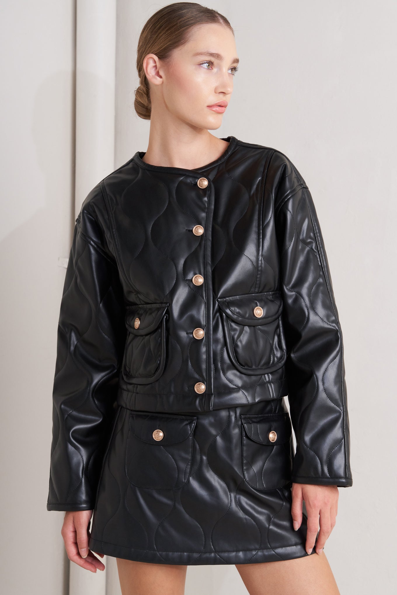 A quilted faux leather jacket with front pockets and button down closure.