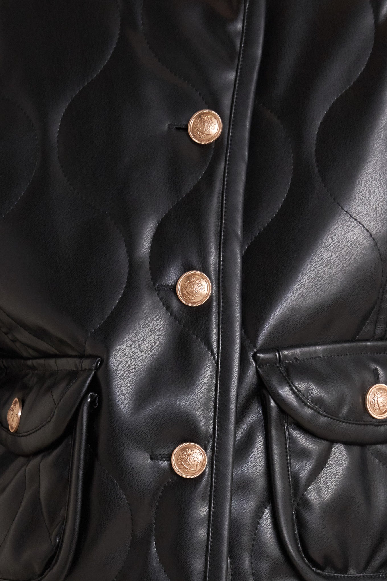 A quilted faux leather jacket with front pockets and button down closure.