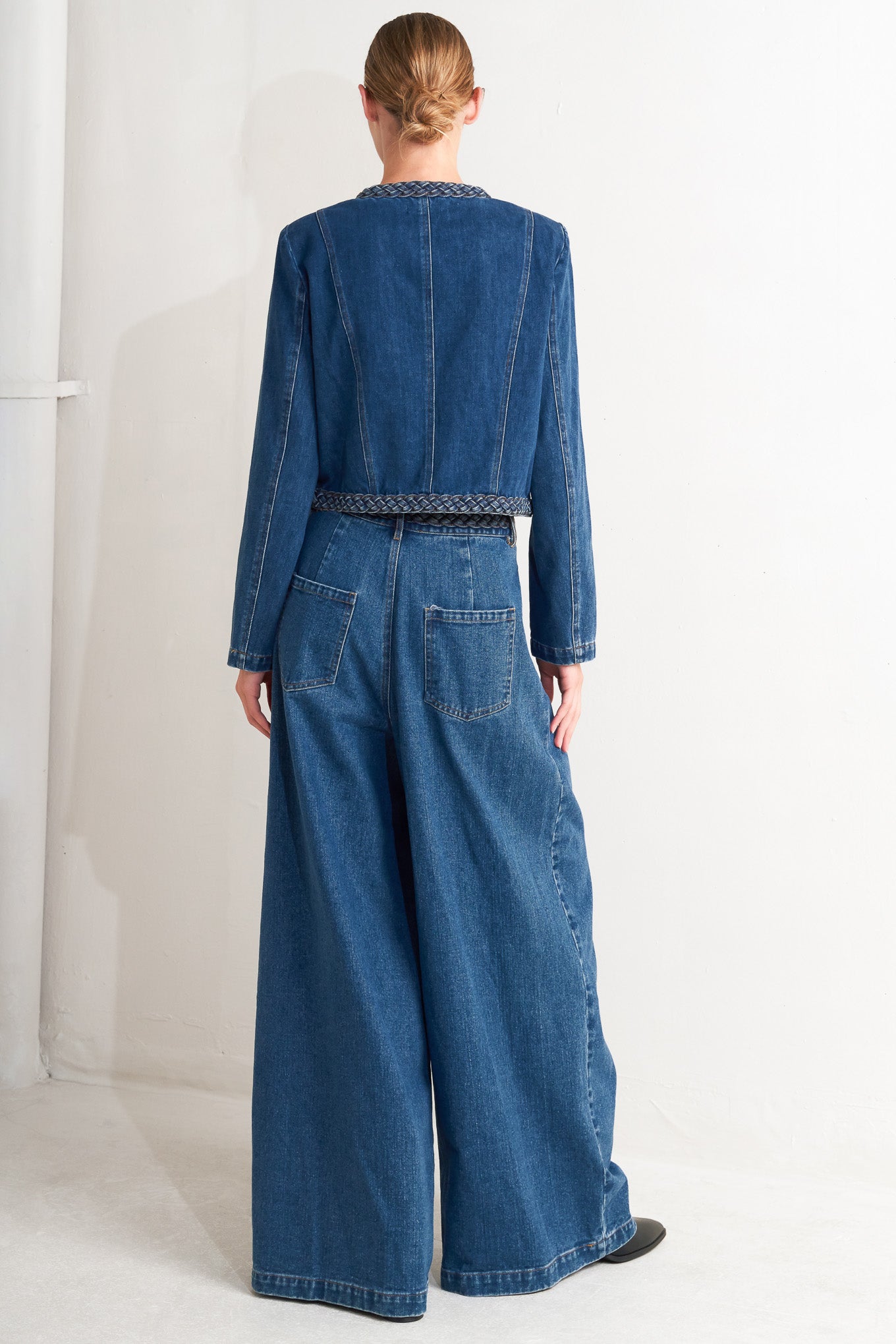 A washed denim jacket featuring round neckline, braided trim and hook &amp; eye closure