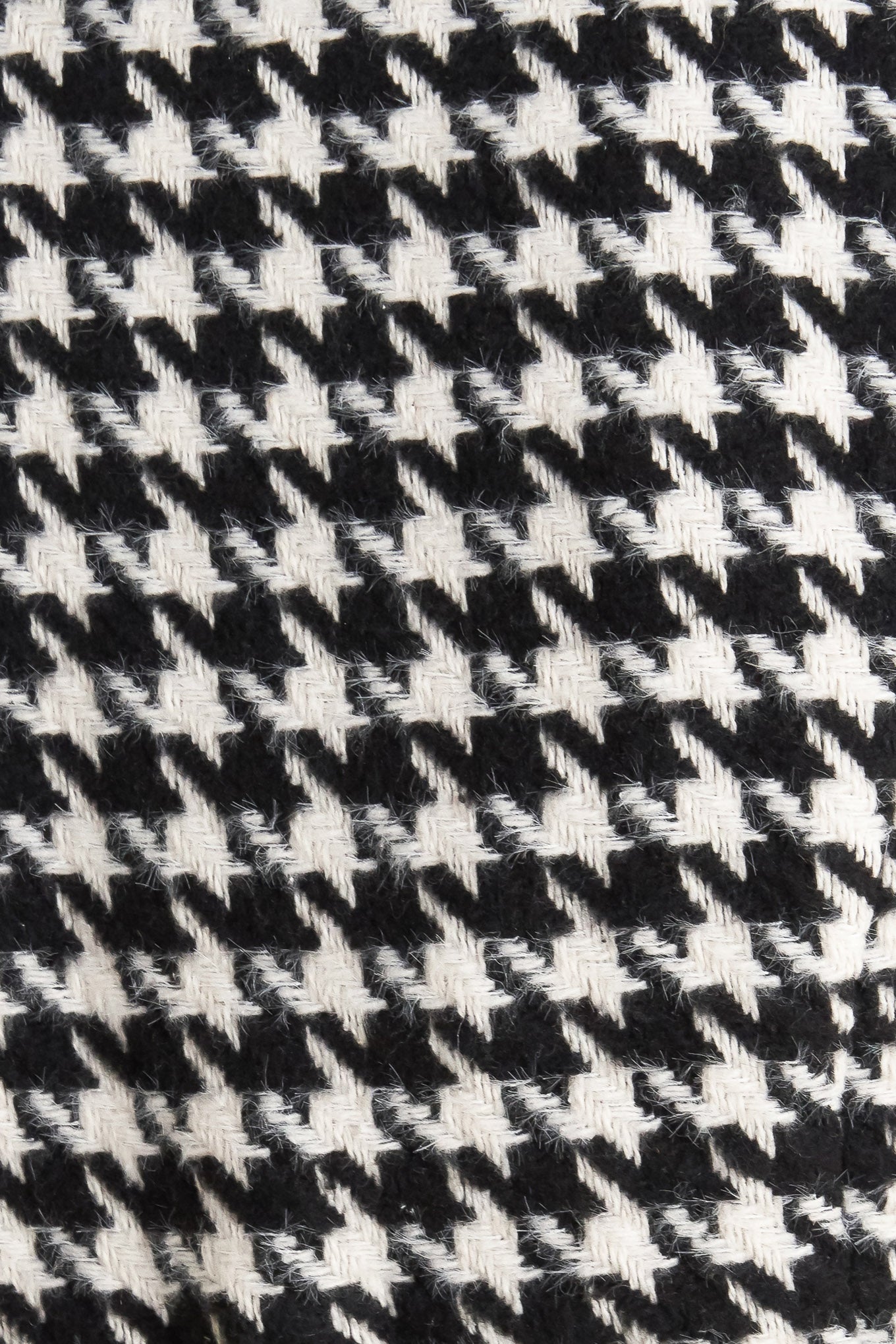 A woven houndstooth vest featuring round neckline, sleeveless and front button down.