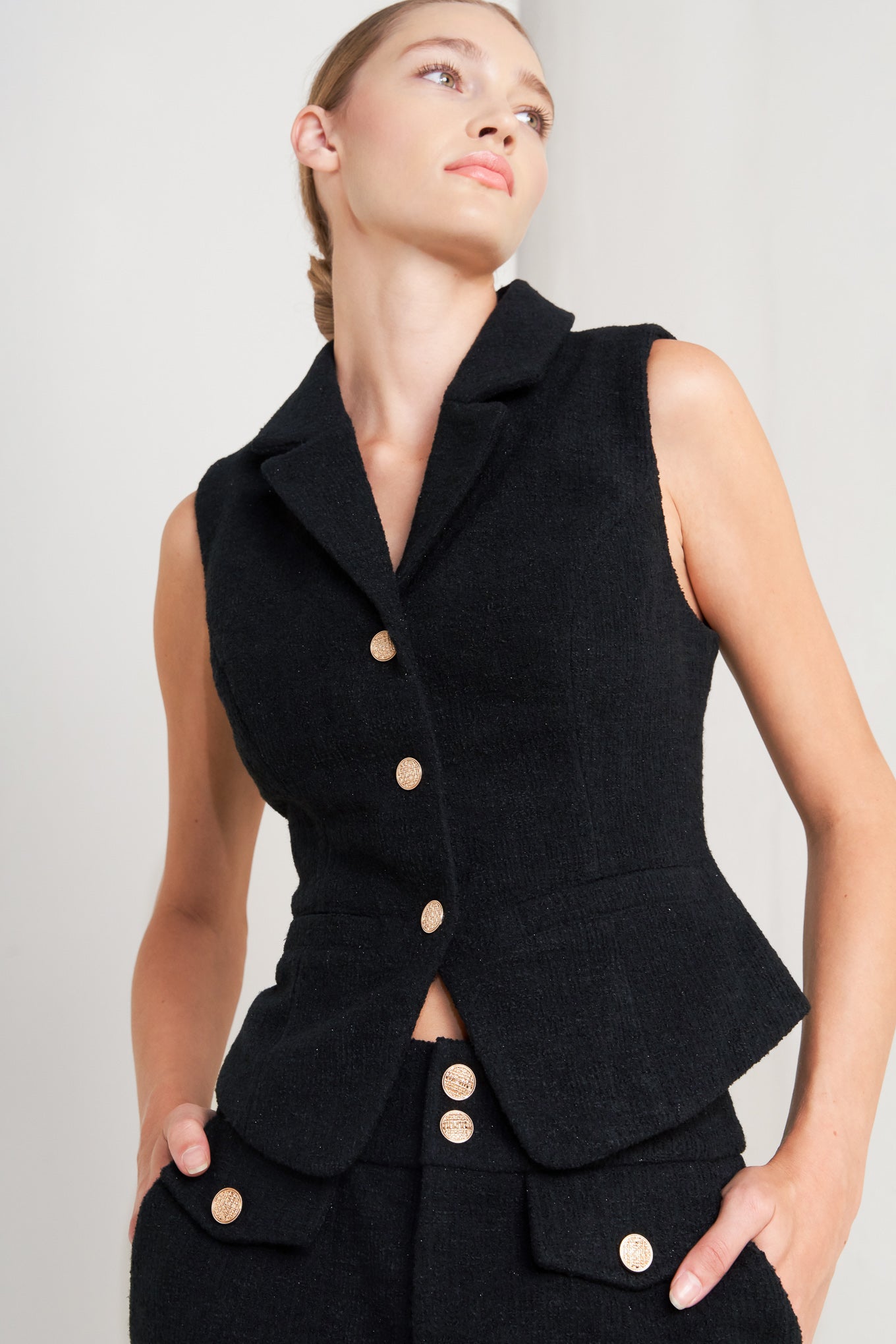 A woven vest featuring collar, sleeveless and front button closure.