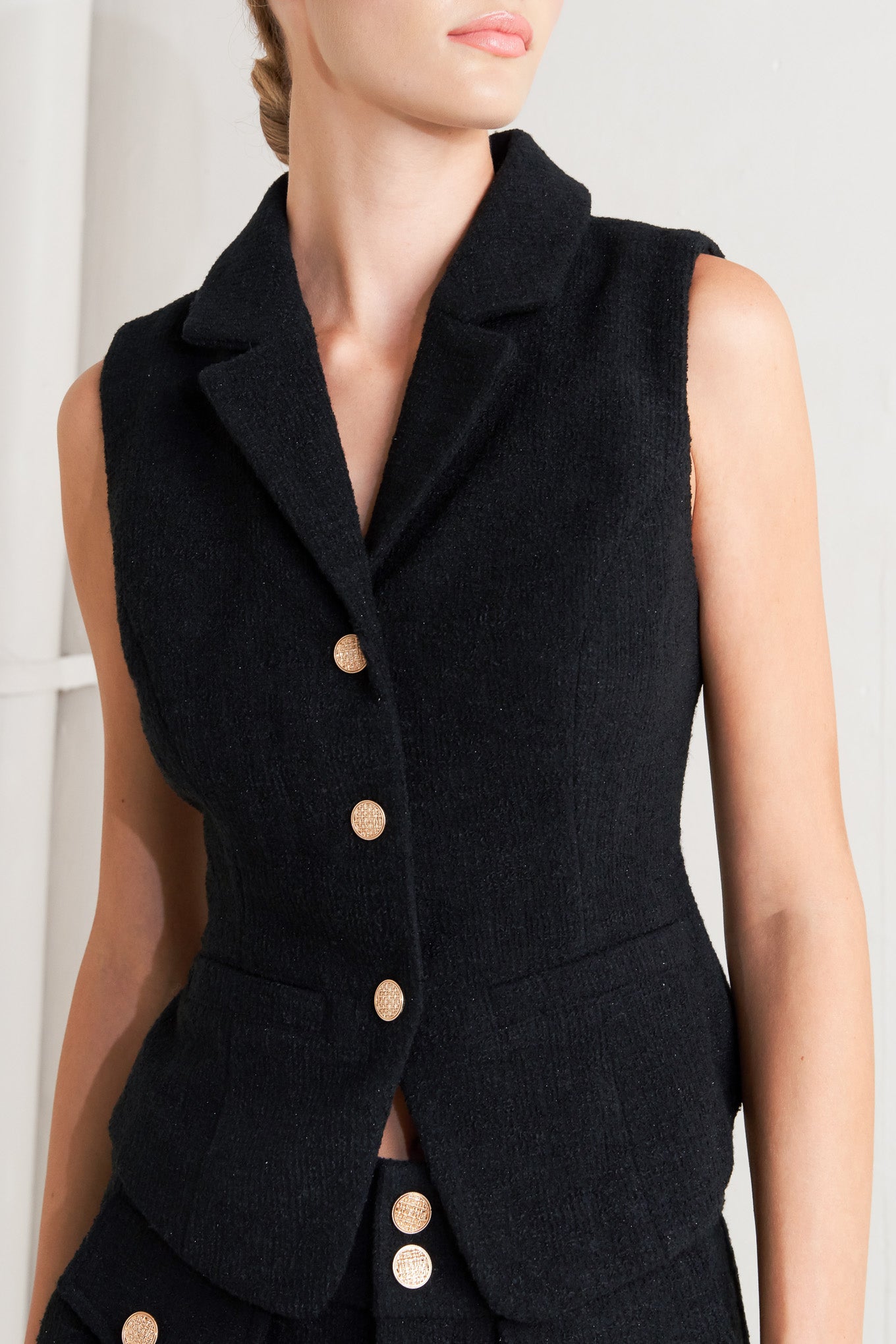 A woven vest featuring collar, sleeveless and front button closure.