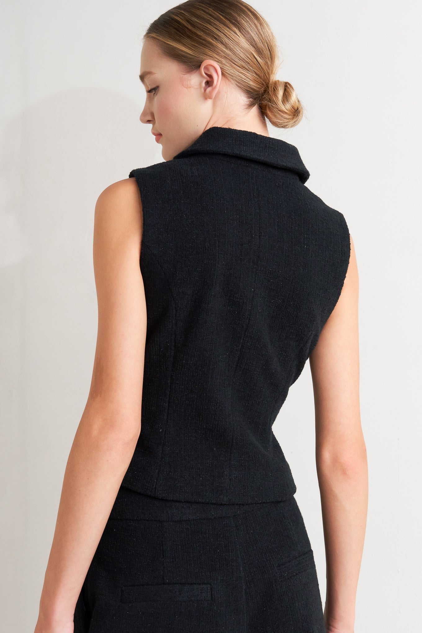 A woven vest featuring collar, sleeveless and front button closure.