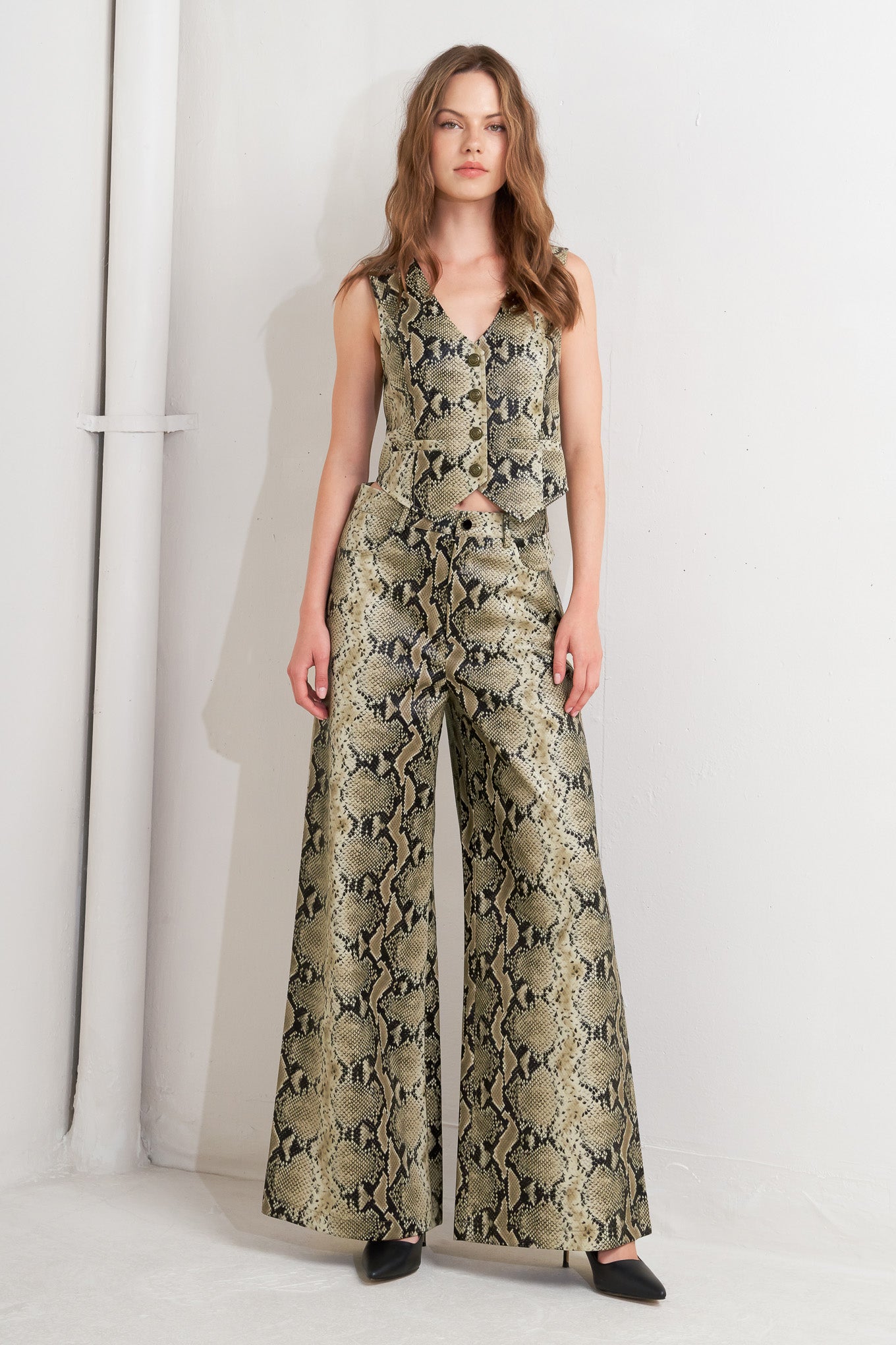 A snake-printed cropped faux leather vest with front button closure.