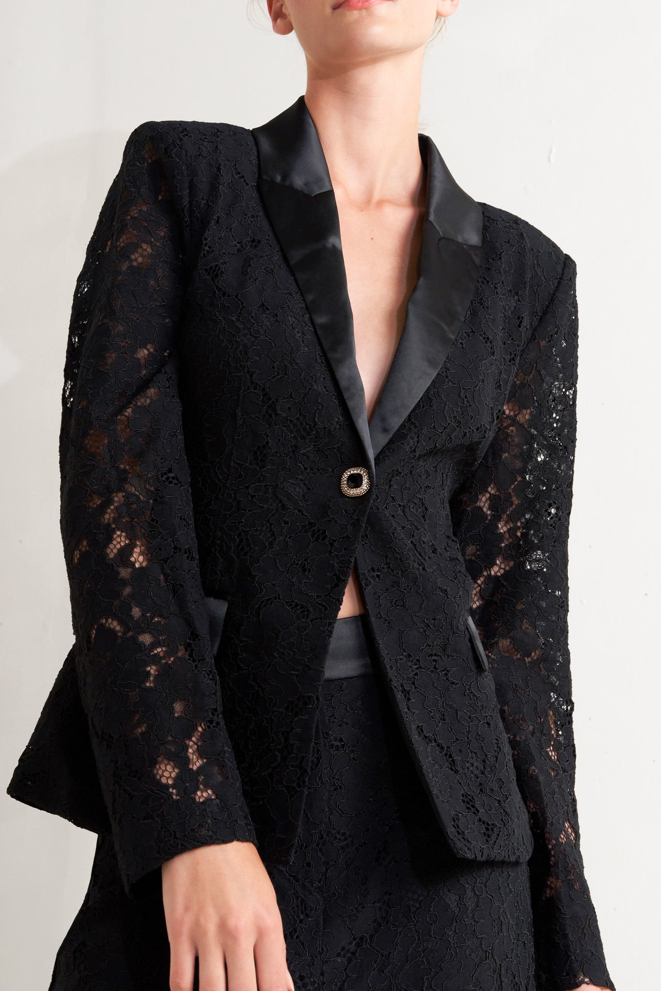 A woven lace blazer with contrasting collar, long sleeve and single button closure.