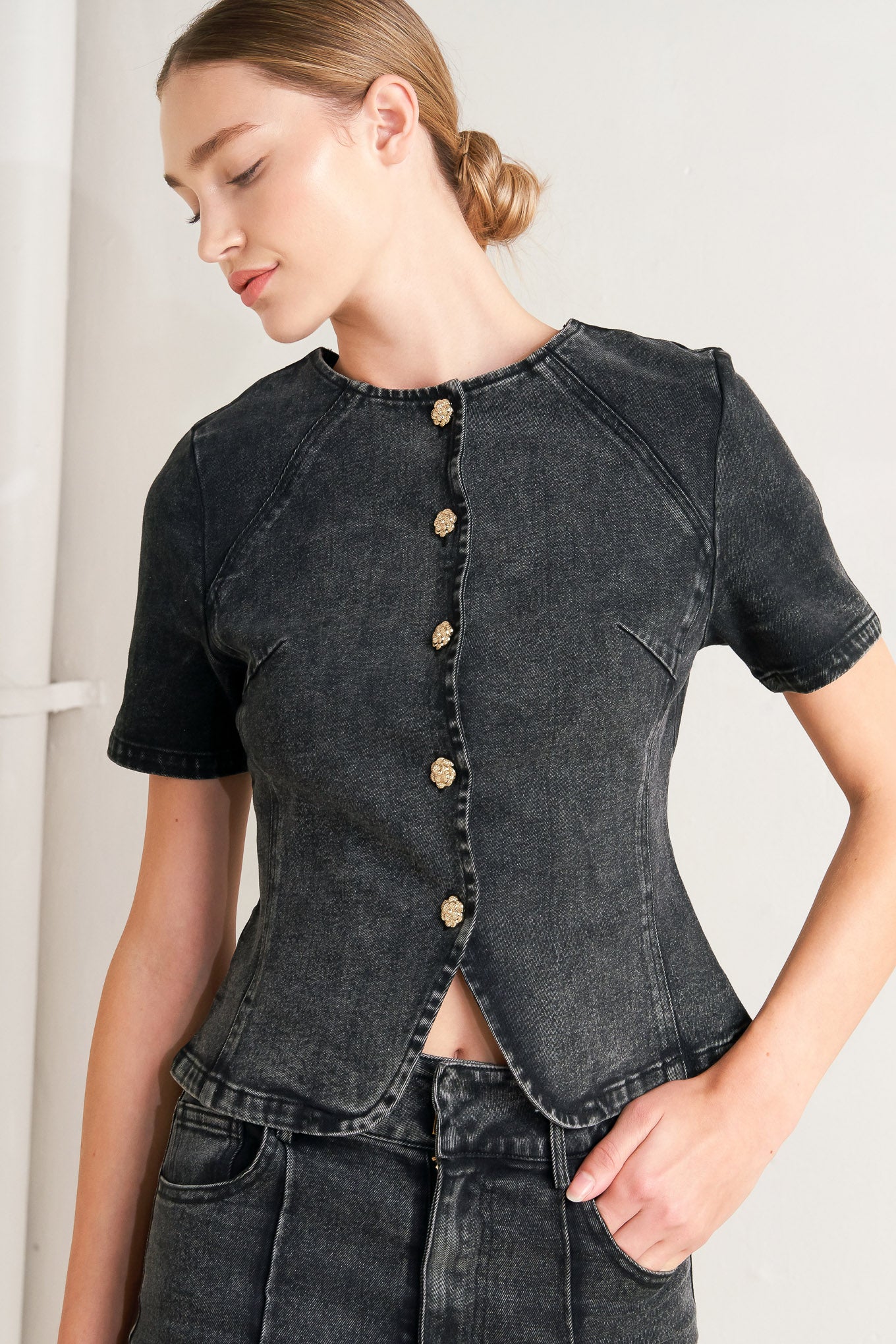A washed denim jacket featuring round neckline, short sleeve and front button down closure. 