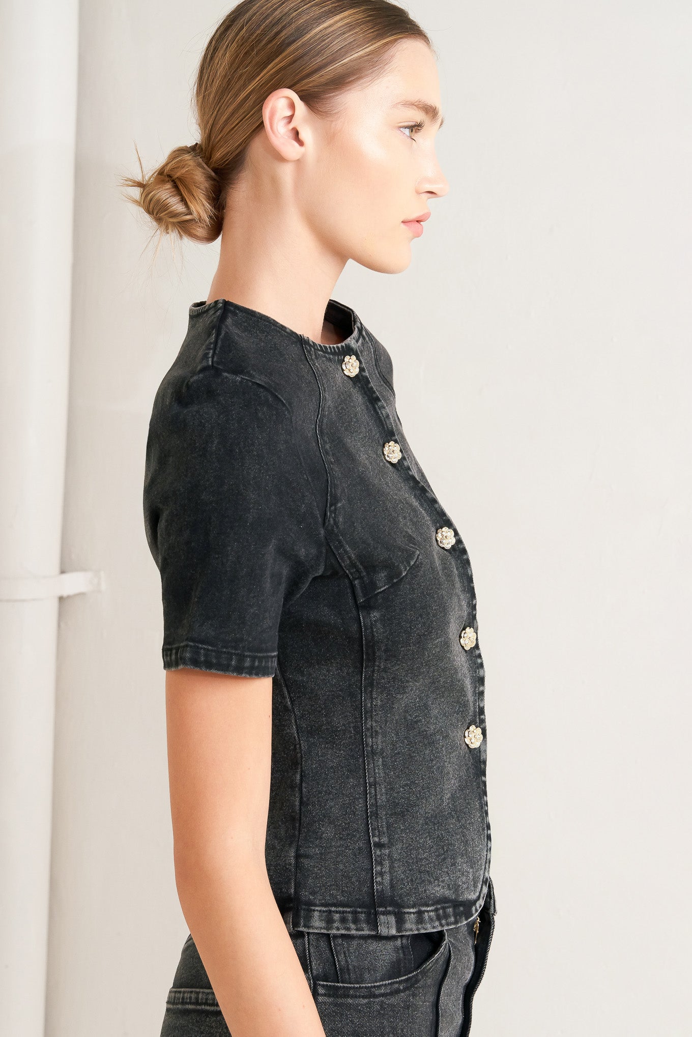 A washed denim jacket featuring round neckline, short sleeve and front button down closure. 