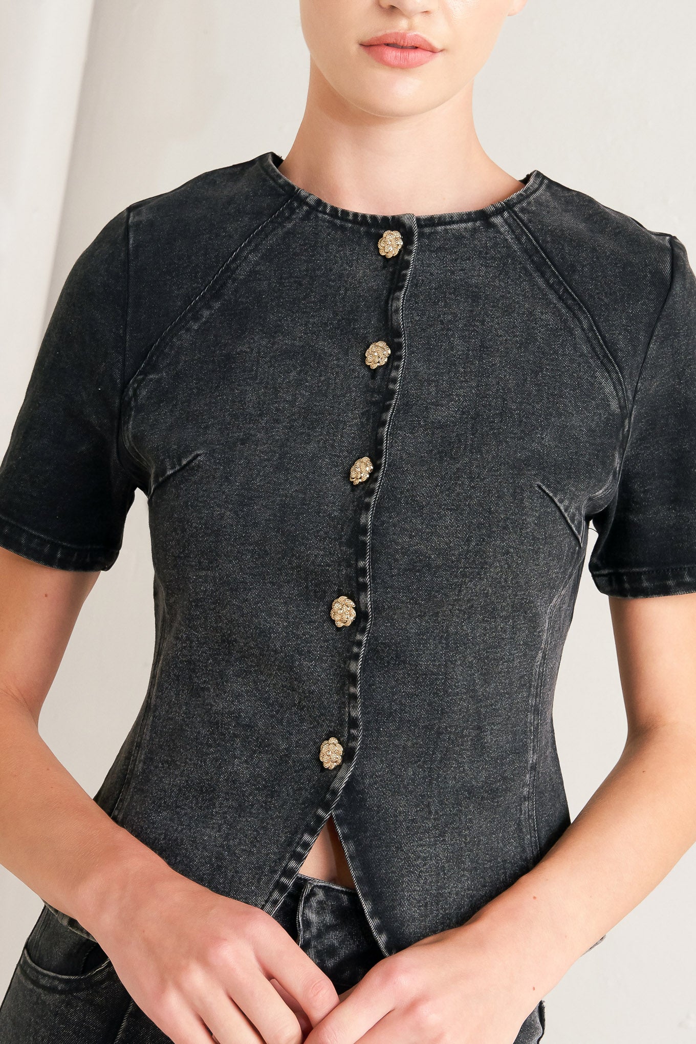 A washed denim jacket featuring round neckline, short sleeve and front button down closure. 
