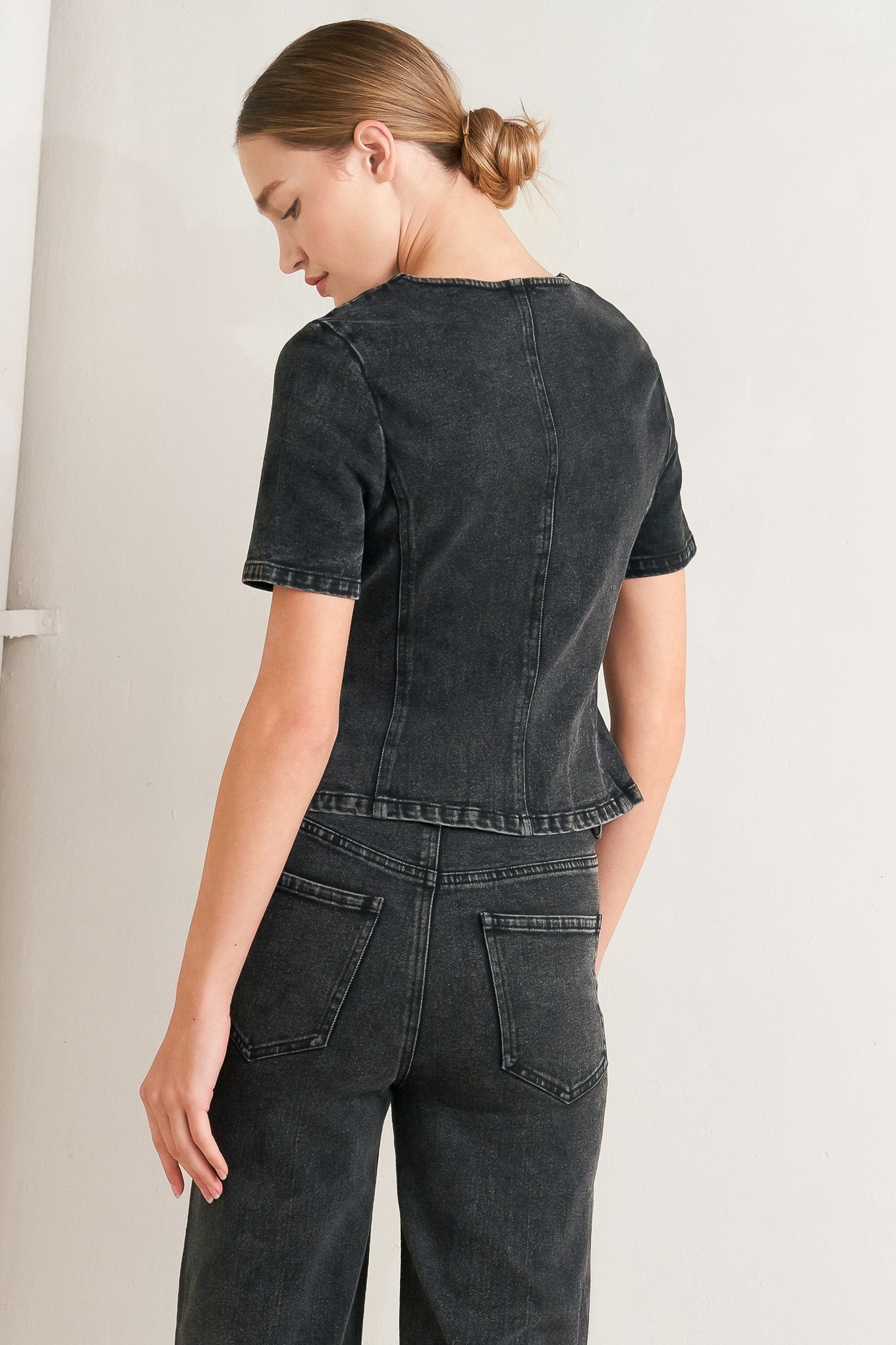 A washed denim jacket featuring round neckline, short sleeve and front button down closure. 