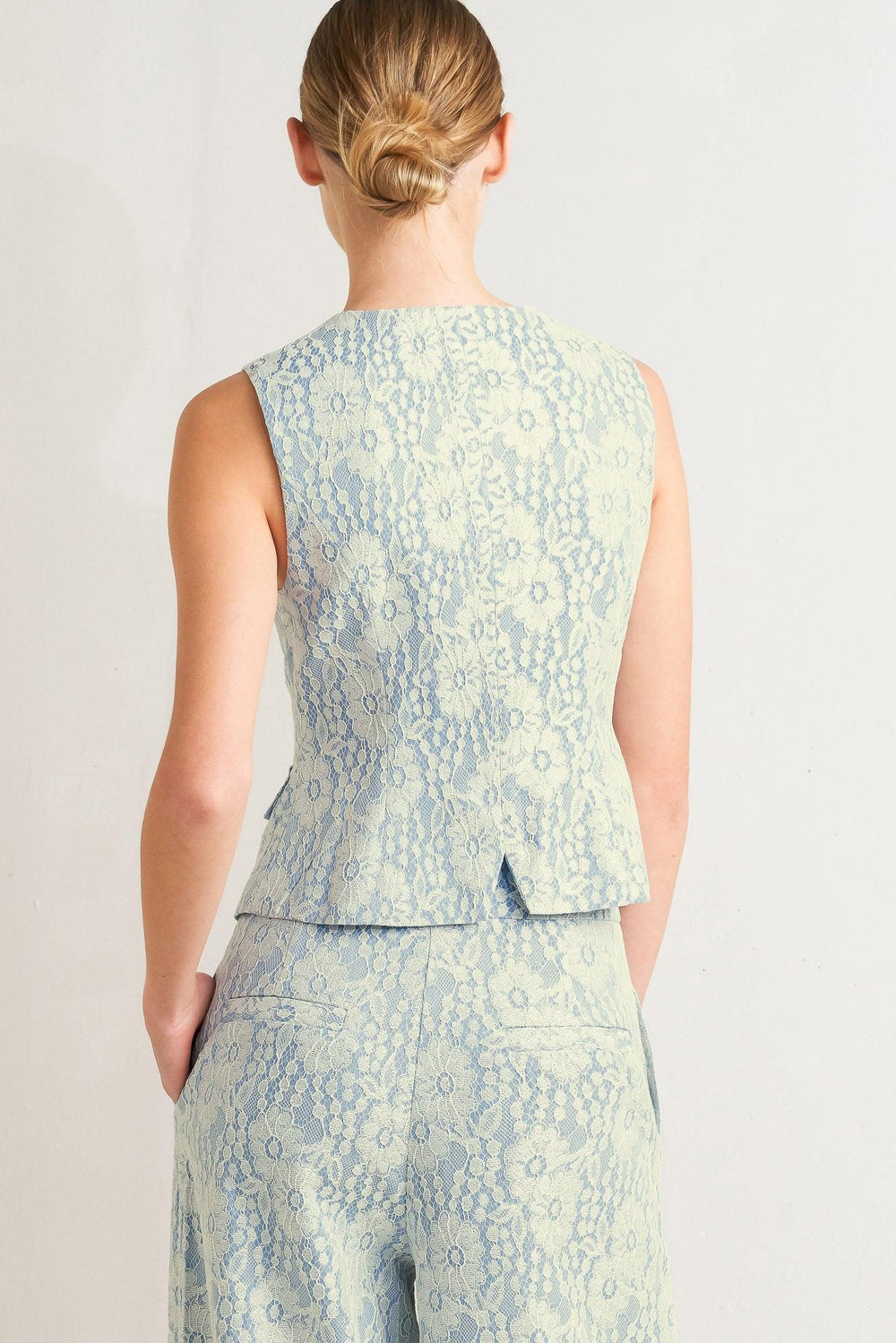 A woven bonded lace vest featuring V neckline, sleeveless and button down

Details:

Self: 50% Rayon 50% Polyester

Size & Fit

-Model is 5`8" And Wearing Size Small
-Measurements Taken From Size Small
-Approx. Length: 22"