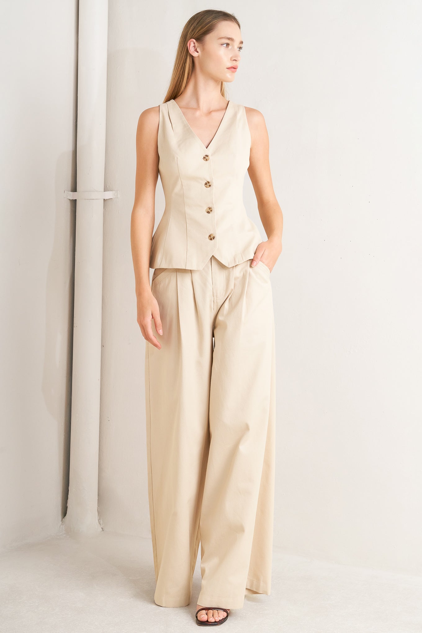 A solid woven vest featuring V neckline, sleeveless, front button down and V back.