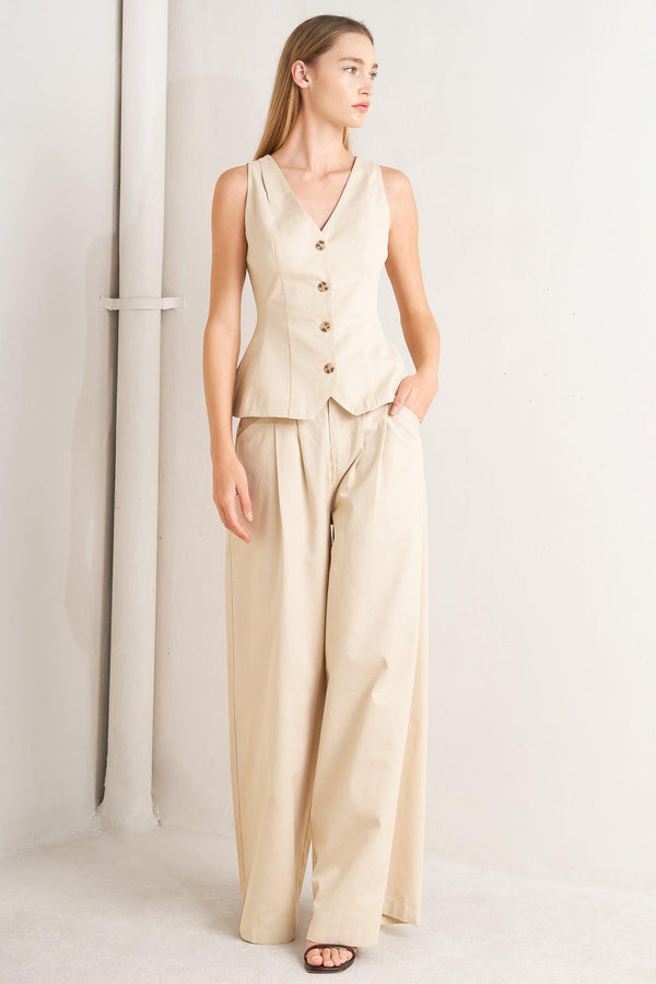 A solid woven vest featuring V neckline, sleeveless, front button down and V back.