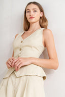 A solid woven vest featuring V neckline, sleeveless, front button down and V back.