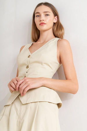 A solid woven vest featuring V neckline, sleeveless, front button down and V back.