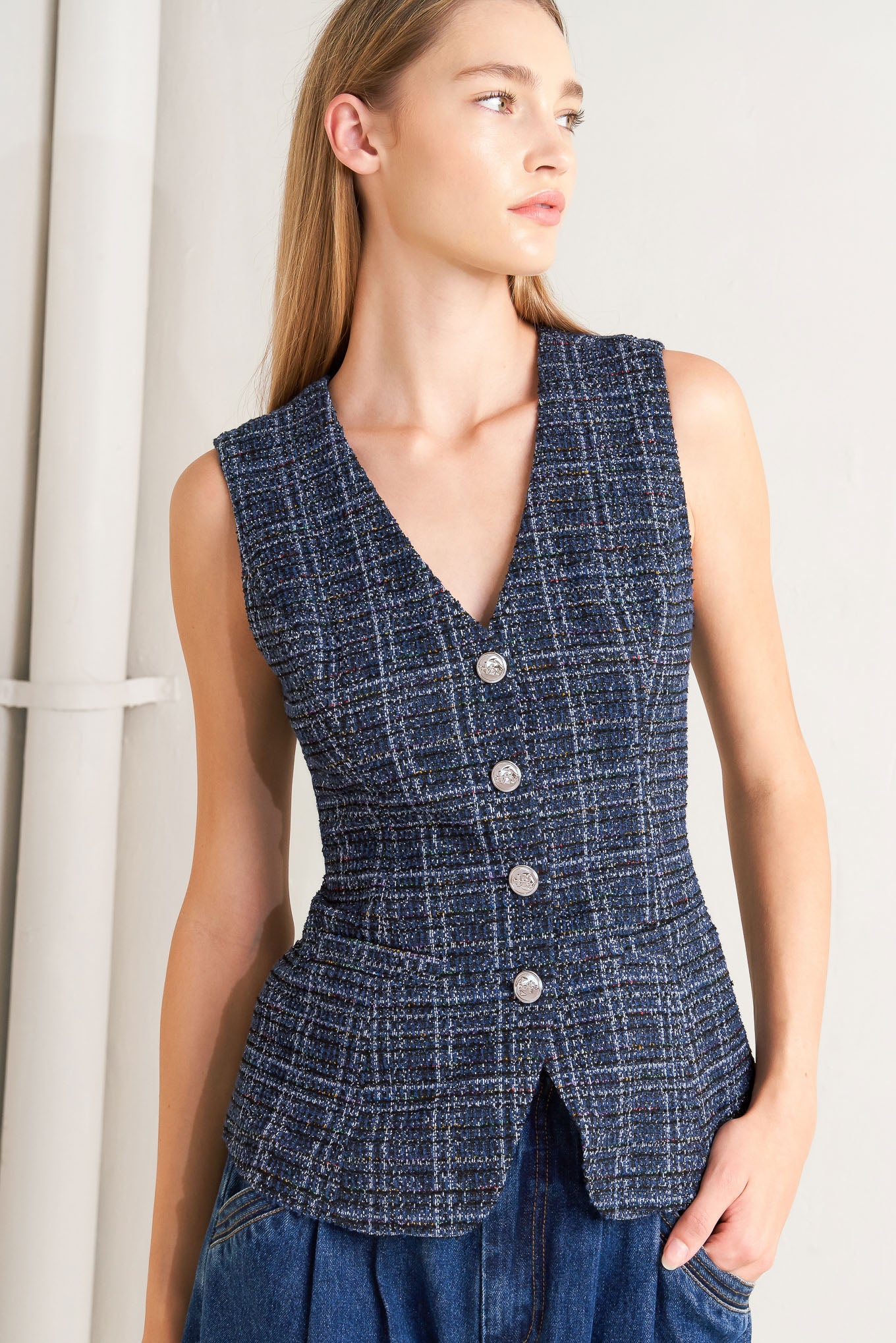 A tweed vest with front button closure