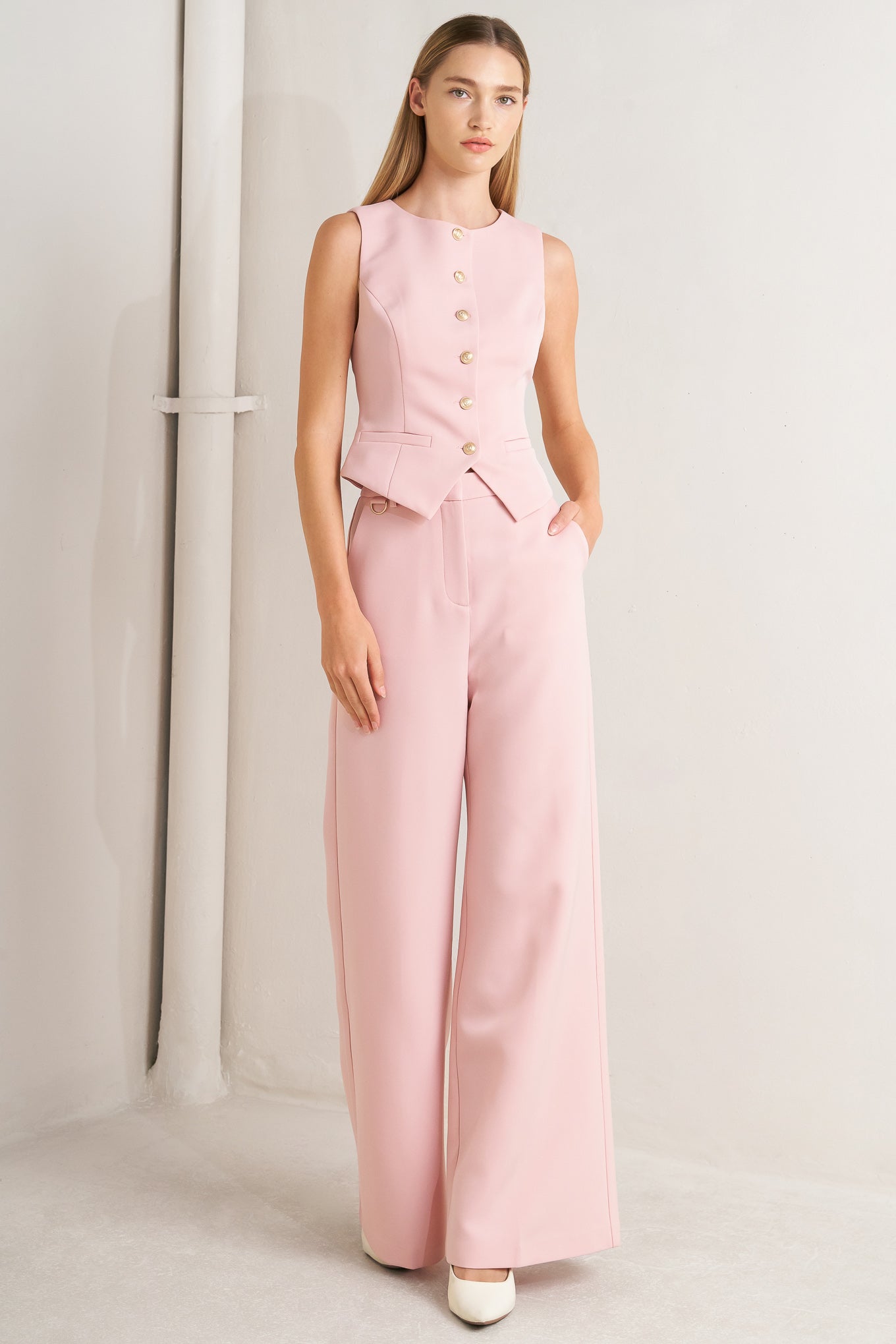 A solid woven vest featuring round neckline, sleeveless and front button down closure.