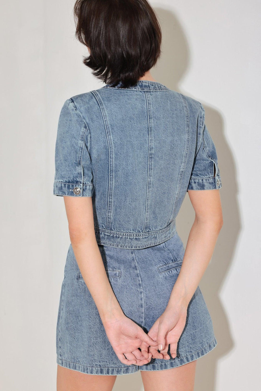 
A washed denim jacket featuring round neckline, short sleeve, front pockets and front button down. Matching skort FP2018T

Details:

Self : 100% Cotton

Size &amp; Fit

- Model is 5`8" And Wearing Size Small
- Measurements Taken From Size Small
- Approx. Length: 19"