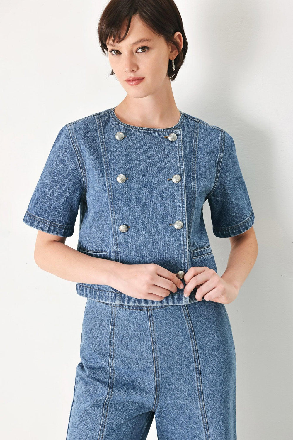 A washed denim jacket featuring round neckline, elbow sleeve, double button down and side pocket.