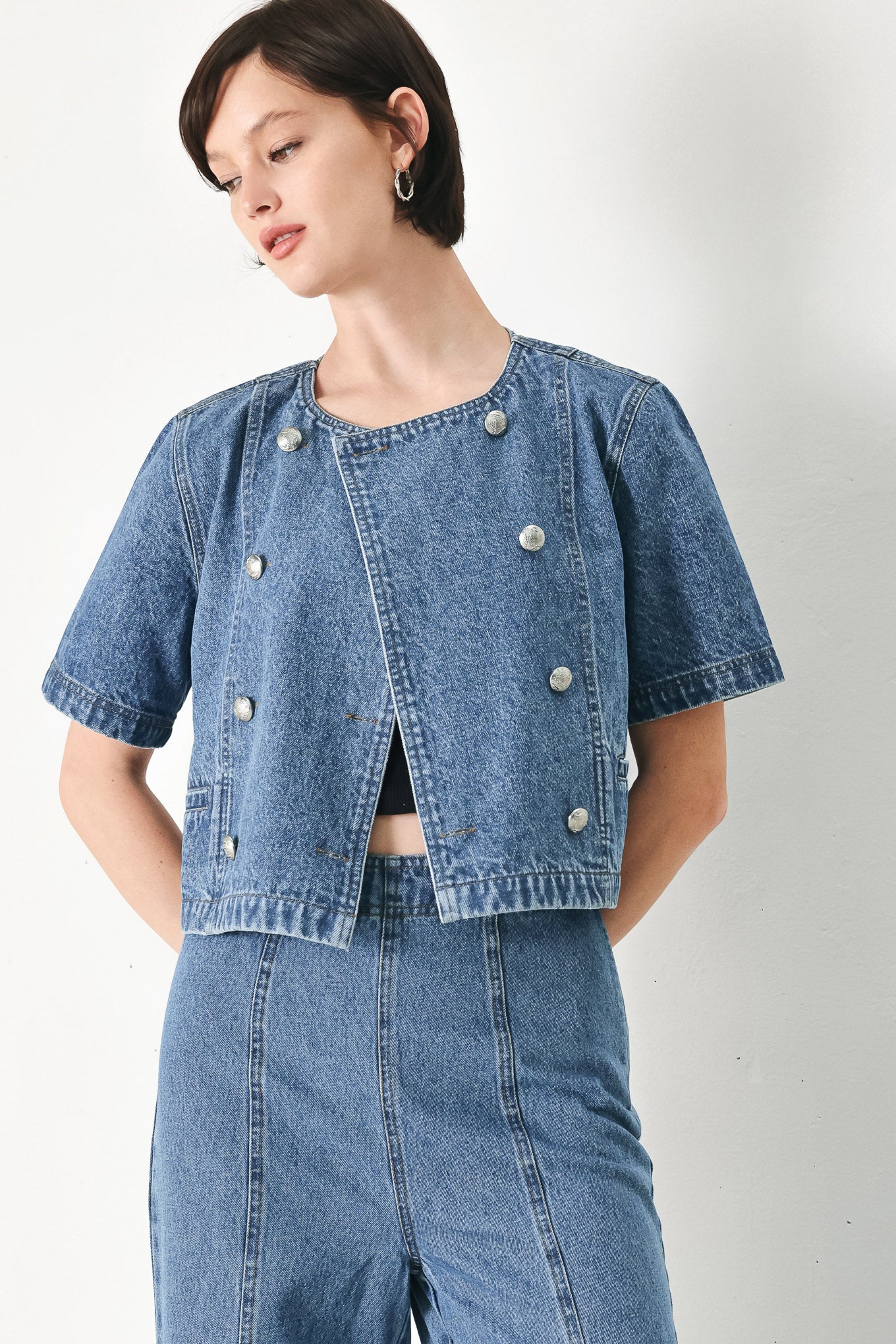 A washed denim jacket featuring round neckline, elbow sleeve, double button down and side pocket.
