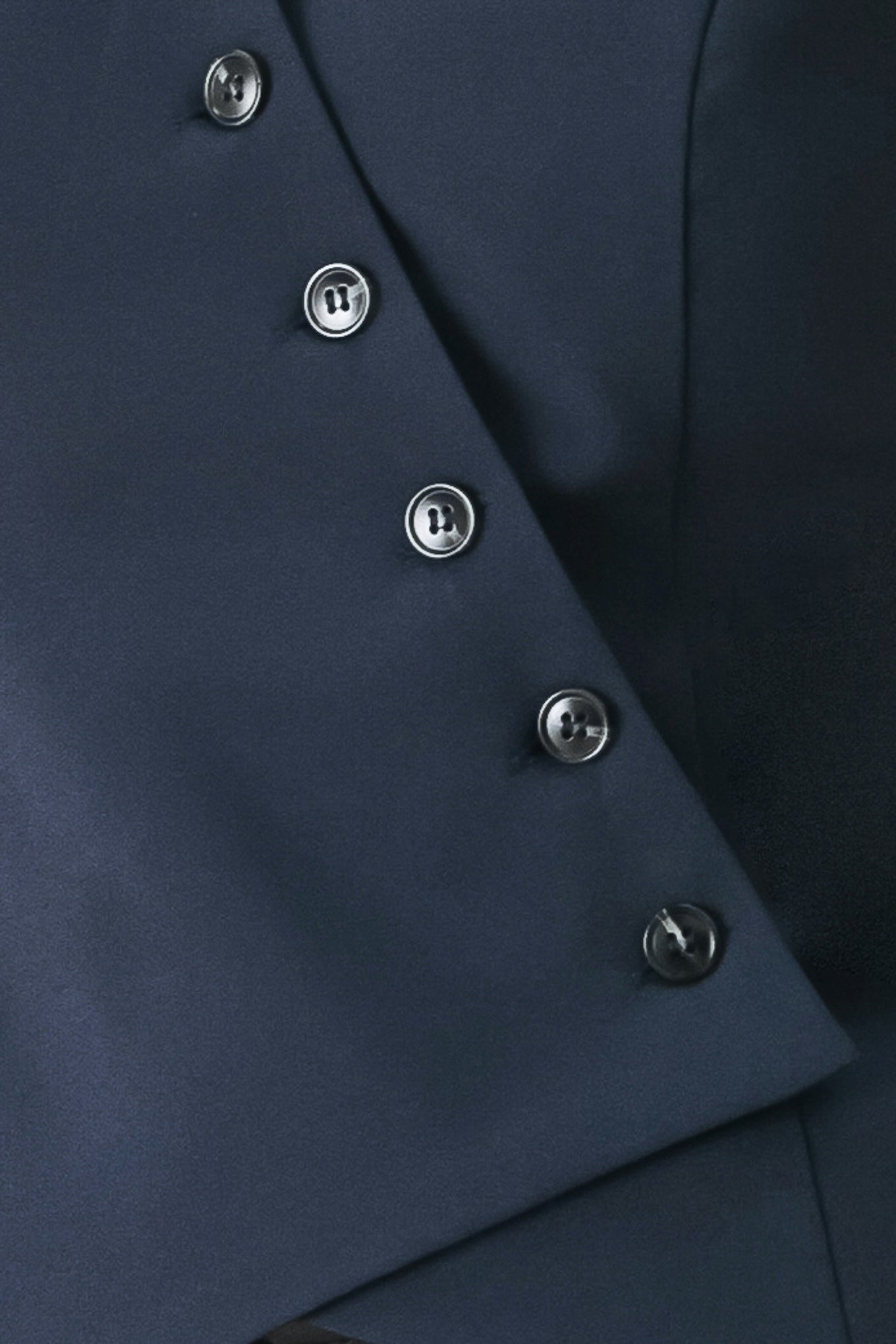 Woman wearing a navy blue sleeveless vest with asymmetrical overlap and buttons | FREEMARKET