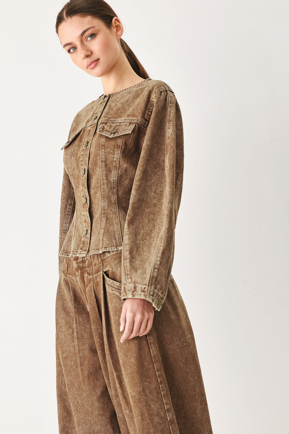 Woman wearing a washed brown denim jacket with round neckline and front button down | FREEMARKET