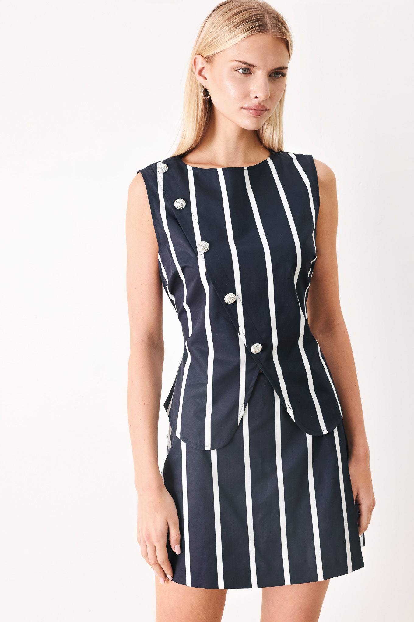Woman wearing a navy and white striped top and skort set with buttons | FREEMARKET