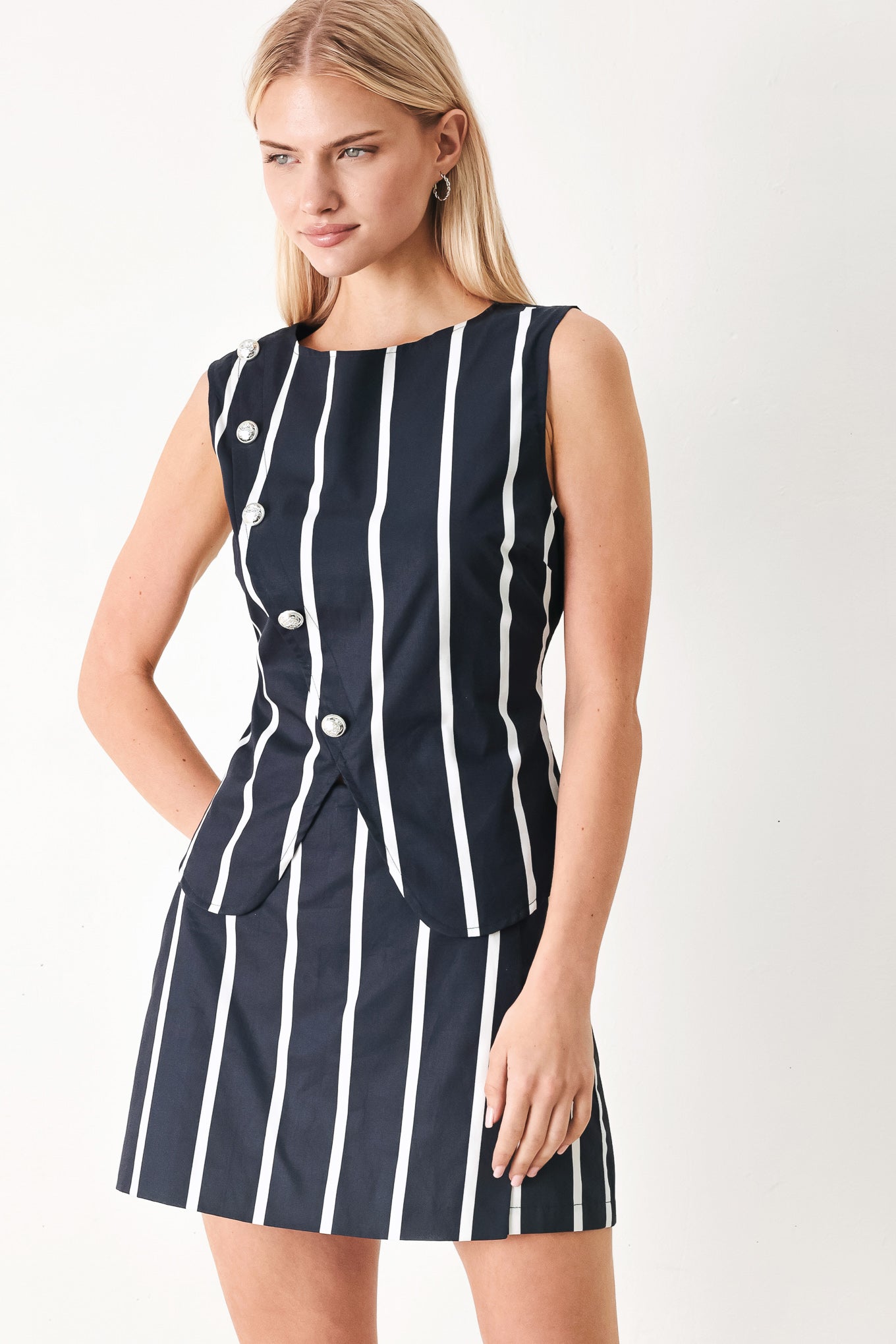 Woman wearing a navy and white striped top and skort set with buttons | FREEMARKET